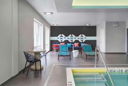 米西索加Tru By Hilton Toronto Airport West的配有桌椅和游泳池的客房
