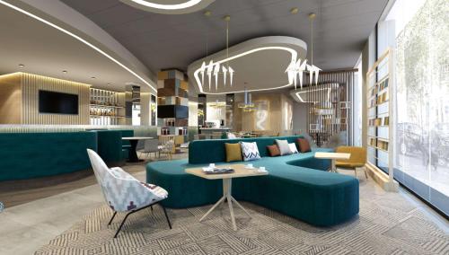 什切青Hampton By Hilton Szczecin East的客厅配有绿色沙发和桌子