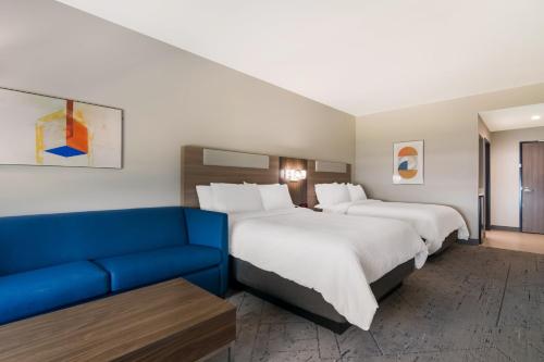 斯普林代尔Holiday Inn Express & Suites - Springdale - Fayetteville Area的酒店客房,设有两张床和一张蓝色的沙发