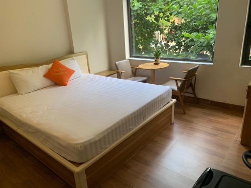 岘港Bao Tran Homestay的一间卧室配有一张床、一张桌子和一个窗户。