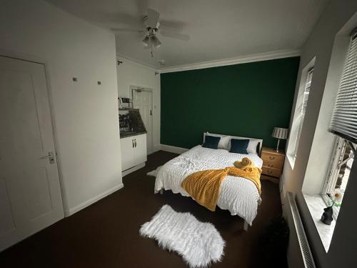 普拉姆斯特德The Griffen Lodge的一间卧室设有一张床和绿色的墙壁