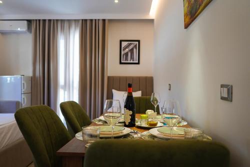 格勒姆DelMar Hotel-Apart的餐桌,配有酒杯和绿椅
