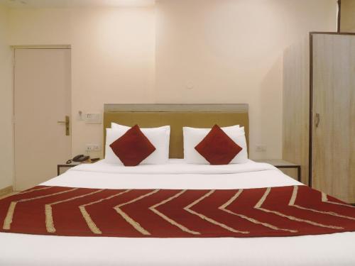 新德里Hotel Grace, Karol Bagh, New Delhi的一间卧室配有红色枕头的床
