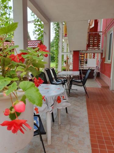 什图罗沃Apartmány Viola的庭院里设有桌子,种植了红花植物