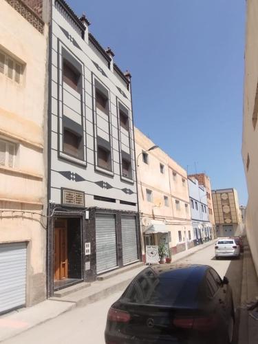 appartement joliment meublé pour 4/5 personnes à Imzouren的停在大楼前的一辆黑色汽车
