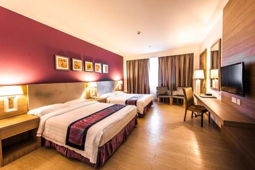 斯里巴加湾市巴迪亚酒店的酒店客房设有两张床和一台平面电视。