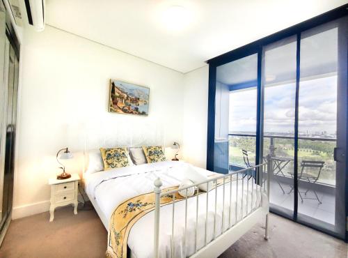 悉尼Cozy Apt w Park View by Stadiums的一间卧室设有一张床和一个大窗户