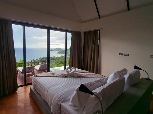 涛岛Taoruna Villa的一间卧室设有一张床,享有海景