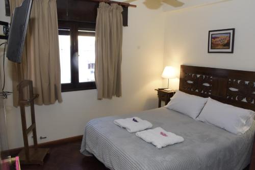圣萨尔瓦多德朱Departamento Balcarce Jujuy 4B的一间卧室配有一张床,上面有两条毛巾