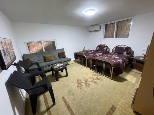 乌姆盖斯Beit Al Hasan بيت الحسن的客厅配有床和沙发