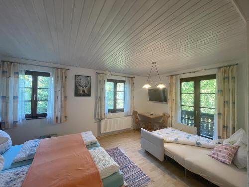 普鲁格恩Farmreiterhof的一间卧室设有两张床、一张沙发和窗户。
