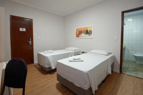 坎皮纳斯Fênix Hotel Campinas的酒店客房带两张床和一间浴室