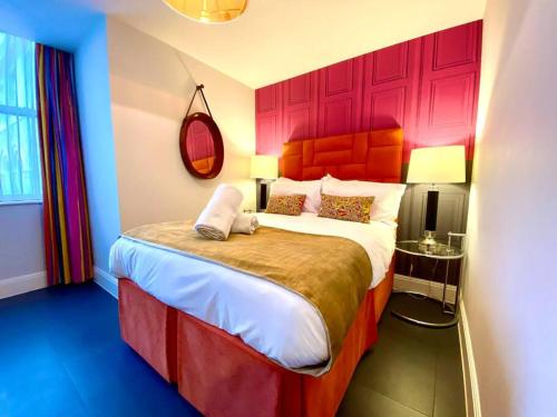 浦耳Incredible Apartment - Amazing Location - Free Parking & WiFi!的一间卧室配有一张大床和红色床头板