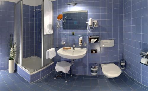 ZeithainHotel Moritz an der Elbe的蓝色瓷砖浴室设有水槽和卫生间