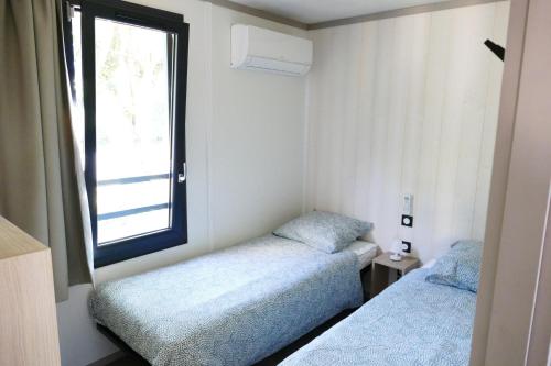 瑞卢维尔莱潘Cottage des Dunes - Chalet de 49m2 climatisé - 6 personnes的小型客房 - 带2张床和窗户
