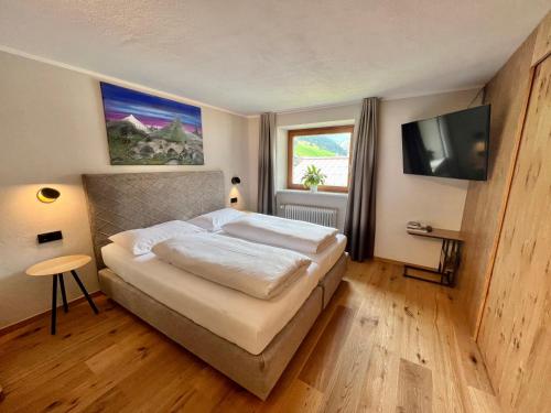 莱赫阿尔贝格斯科洛芬斯坦住宿加早餐旅馆的一间卧室配有一张床和一台平面电视