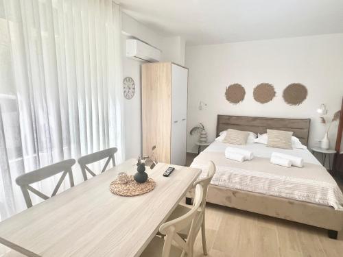 都拉斯Art Studio Apartments Durrës的卧室配有一张床和一张桌子及椅子