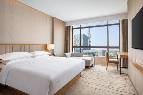 上海上海万信福朋喜来登酒店的酒店客房设有一张床和一个大窗户
