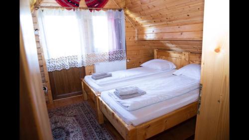 阿列谢尼Casa dintre Brazi的小木屋内一间卧室,配有两张床