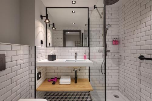 里斯本Moxy Lisbon City的一间带水槽和镜子的浴室