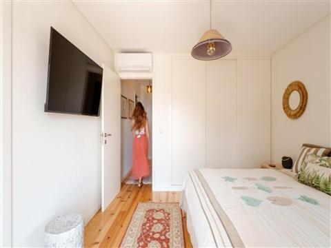 MártirOuteiro Douro House的走廊上的卧室配有一张床和一个女孩