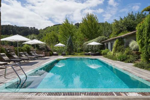 吉塔里亚伊图雷吉酒店的庭院内带椅子和遮阳伞的游泳池