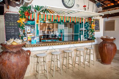 克拉伦代克Bonaire 2 Stay Playa的酒吧,带凳子和一个带时钟的柜台