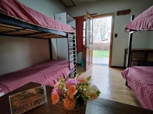 乌斯怀亚House 1903的客房设有两张双层床和一张带鲜花的桌子。