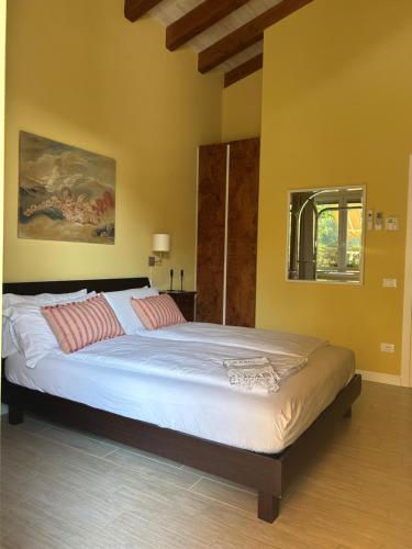 阿尔蒙诺圣巴特鲁姆Agriturismo Al Robale的一间卧室配有一张大床,配有白色床单和红色枕头