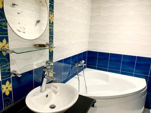 开罗Airport hostel room for transit的蓝色和白色的浴室设有水槽和浴缸。