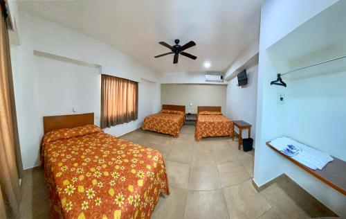 韦拉克鲁斯德费内尔斯酒店的一间卧室配有两张床和吊扇