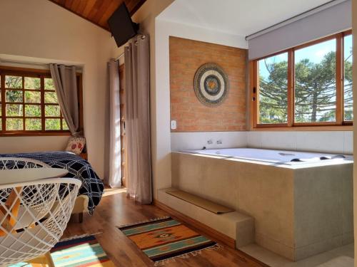 圣安东尼奥-杜皮尼亚尔Pousada Reserva Nativida的带浴缸和窗户的大浴室
