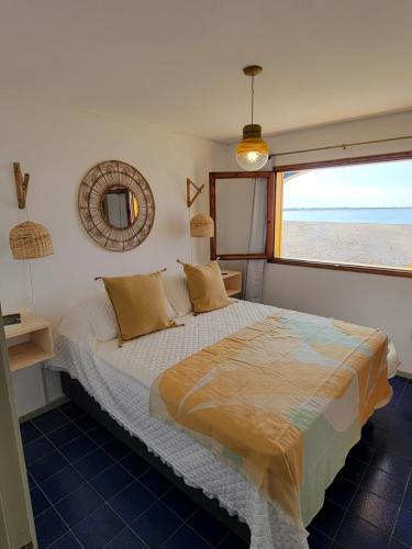 拉帕洛马Apartamentos Alborada的一间卧室配有一张床,享有海滩美景