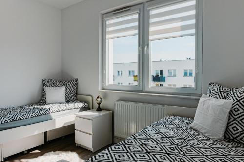 特切夫Jak u siebie w domu. Apartament w nowej dzielnicy.的一间卧室设有一张床和一个窗口