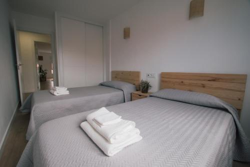 格罗韦Laxiela Apartment的客房内的两张床和白色毛巾