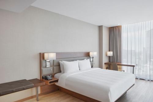 萨尔蒂约AC Hotel by Marriott Saltillo的卧室设有白色的床和大窗户