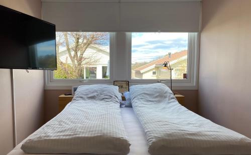 格里姆斯塔Privat hjem i Grimstad - Nær Arendal og Dyreparken的卧室在窗户前配有两张床