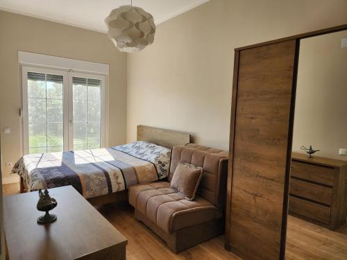 普里什蒂纳Shtepia e Malit的一间卧室配有一张床、一张沙发和一把椅子