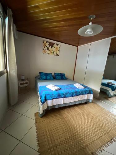 PaeaFare Moehani的一间卧室配有一张带蓝色枕头的床和天花板