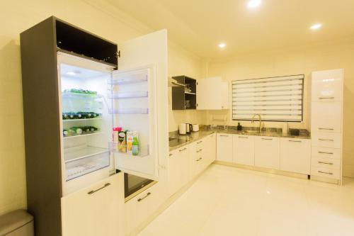 库马西Kumasi Luxury Apartments @ The Fairview的厨房配有白色橱柜和冰箱。