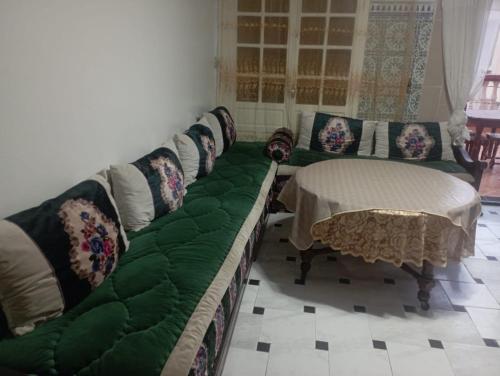 Oulad AkkouSablettes的客厅配有绿色沙发和桌子