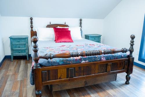 帕尔默Snodgrass Suite 301, Hyland Hotel的一间卧室配有一张红色枕头的床