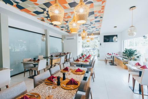 赫拉多拉Paradise Bay Hotel Boutique的餐厅设有桌椅和色彩缤纷的天花板。