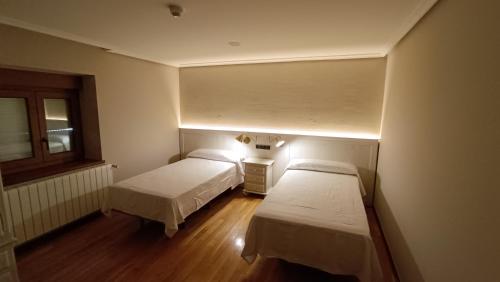Casa Elisa Monegro.的一间设有两张床的客房,墙上有一盏灯