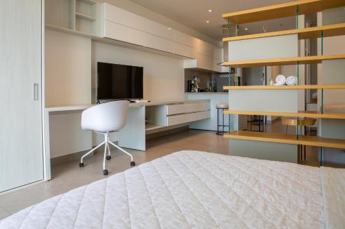 巴兰基亚Distrito 90的一间卧室配有一张床、一张书桌和一台电视