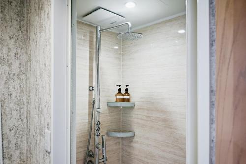 长崎卡萨野田青年旅馆的带淋浴的浴室和玻璃门