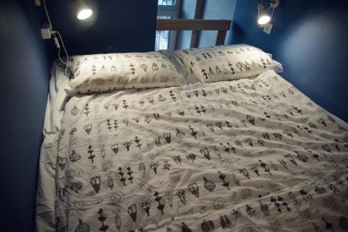 沃罗涅什Geek Hostel & Hotel的床上有毯子
