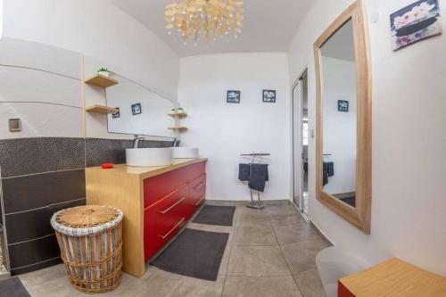 拜马欧La Villa Mussanda avec piscine的厨房配有红色橱柜和镜子