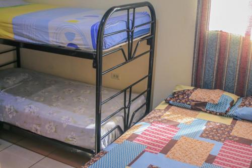 马塔加尔帕Homestay Matagalpa的配有两张双层床的客房,配有被子
