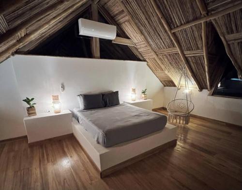 波波约Jungle Shacks : Hoku Casita的铺有木地板的客房内设有一间卧室和一张床。